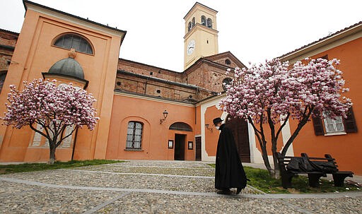 In this photo taken on Thursday, March 12, 2020, a priest wearing a mask walks in Codogno, Italy. The northern Italian town that recorded Italy&#146;s first coronavirus infection has offered a virtuous example to fellow Italians, now facing an unprecedented nationwide lockdown, that by staying home, trends can reverse. Infections of the new virus have not stopped in Codogno, which still has registered the most of any of the 10 Lombardy towns Italy&#146;s original red zone, but they have slowed. For most people, the new coronavirus causes only mild or moderate symptoms. For some it can cause more severe illness. (AP Photo/Antonio Calanni)