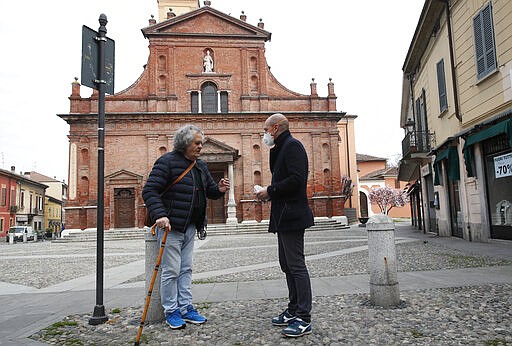 In this photo taken on Thursday, March 12, 2020, Codogno's mayor Francesco Passerini, right, talks to a citizen in Codogno, Italy. The northern Italian town that recorded Italy&#146;s first coronavirus infection has offered a virtuous example to fellow Italians, now facing an unprecedented nationwide lockdown, that by staying home, trends can reverse. Infections of the new virus have not stopped in Codogno, which still has registered the most of any of the 10 Lombardy towns Italy&#146;s original red zone, but they have slowed. For most people, the new coronavirus causes only mild or moderate symptoms. For some it can cause more severe illness. (AP Photo/Antonio Calanni)