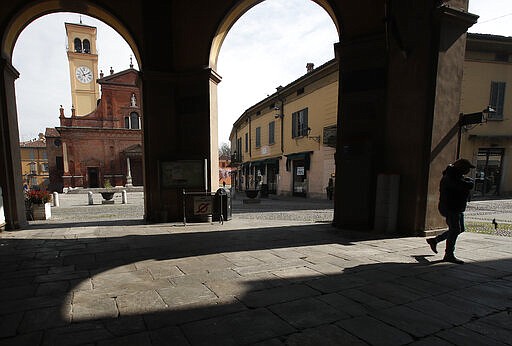 In this photo taken on Thursday, March 12, 2020, a man walks in Codogno, Italy. The northern Italian town that recorded Italy&#146;s first coronavirus infection has offered a virtuous example to fellow Italians, now facing an unprecedented nationwide lockdown, that by staying home, trends can reverse. Infections of the new virus have not stopped in Codogno, which still has registered the most of any of the 10 Lombardy towns Italy&#146;s original red zone, but they have slowed. For most people, the new coronavirus causes only mild or moderate symptoms. For some it can cause more severe illness. (AP Photo/Antonio Calanni)