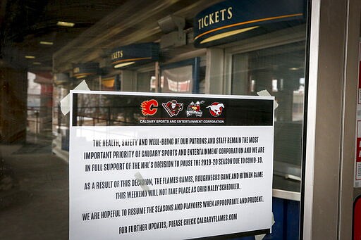 A noticed is affixed to a door of the Saddledome, home of the Calgary Flames, in Calgary, Alberta, Thursday, March 12, 2020. The NHL has suspended the season due to the coronavirus. (Jeff McIntosh/The Canadian Press via AP)