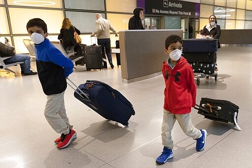 Passengers arrive on a flight from Paris at Logan International Airport in Boston, Friday, March, 13, 2020. Beginning at midnight Friday most Europeans will be banned from entering the United States for 30 days to try to slow down the spread of the coronavirus. Americans returning from Europe will be subject to enhanced health screening. For most people, the new coronavirus causes only mild or moderate symptoms, such as fever and cough. For some, especially older adults and people with existing health problems, it can cause more severe illness, including pneumonia. The vast majority of people recover from the new virus. (AP Photo/Michael Dwyer)