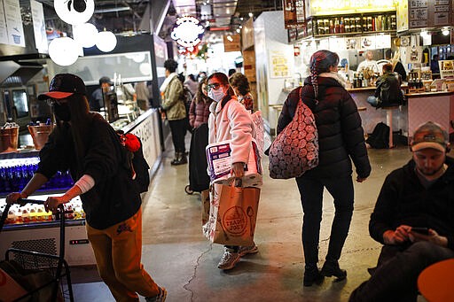 Shoppers wear masks while carrying their groceries out of a supermarket, Thursday, March 12, 2020, in the Brooklyn borough of New York.  Mayor Bill de Blasio said Thursday he will announce new restrictions on gatherings to halt the spread of the new coronavirus in the coming days, but he hopes to avoid closing all public events such as Broadway shows.  The vast majority of people recover from the new coronavirus. According to the World Health Organization, most people recover in about two to six weeks, depending on the severity of the illness. (AP Photo/John Minchillo)