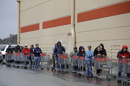 Shoppers wait to enter a Costco warehouse Saturday, March 14, 2020, in Santa Clarita, Calif.  Efforts to stop the spread of the coronavirus in California are affecting virtually every facet of life in the Golden State in ways big and small  and in some cases, surreal. Popular restaurants were desperate for patrons, and typically crowded gyms had plenty of floor space. Some stores limited sales of toilet paper and other goods to combat hoarding.  The vast majority of people recover from the new coronavirus. According to the World Health Organization, most people recover in about two to six weeks, depending on the severity of the illness. (AP Photo/Marcio Jose Sanchez)