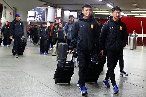 Players of the Chinese Super League team Wuhan Zall arrive at the Atocha train station in Madrid, Spain, Saturday, Feb. 29, 2020. The Chinese first-division soccer club from the city of Wuhan enters its second month in Spain without knowing when it will be able to return home. . It hasn't been easy for the nearly 50 members of the Wuhan Zall squad, but on Sunday they will get some reprieve from their ordeal by attending the Spanish league &quot;clasico&quot; between Real Madrid and Barcelona at the Santiago Bernabeu Stadium in Madrid. (AP Photo/Manu Fernandez)