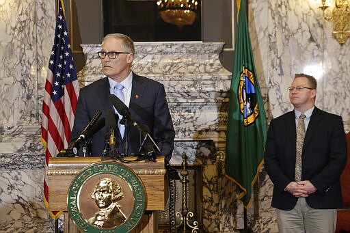 Washington Gov. Jay Inslee, left, is joined by Superintendent of Public Instruction Chris Reykdal as he discusses the expansion of school closures and prohibition of large gatherings across all of Washington in an effort to slow the spread of the new coronavirus, Friday, March 13, 2020. Inslee issued the executive orders, saying the virus is spreading rapidly across the state. Previously, school closures and prohibitions of large gatherings had only been ordered in the three counties with the highest numbers of cases. (AP Photo/Rachel La Corte)