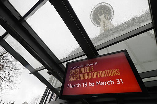 A sign informs visitors that Space Needle is closed, Friday, March 13, 2020, in Seattle. The iconic landmark and tourist attraction closed Friday and will remain so through the end of March due to the outbreak of the COVID-19 coronavirus in Washington state.  The vast majority of people recover from the new coronavirus. According to the World Health Organization, most people recover in about two to six weeks, depending on the severity of the illness. (AP Photo/Ted S. Warren)