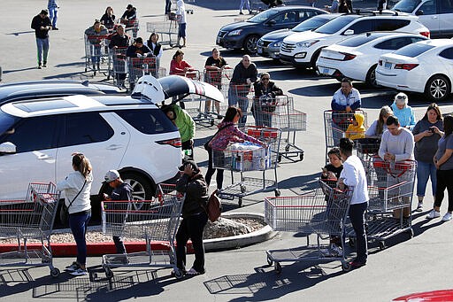 A line of people waiting to buy supplies amid coronavirus fears snakes through a parking lot at a Costco, Saturday, March 14, 2020, in Las Vegas. For most people, the new coronavirus causes only mild or moderate symptoms. For some it can cause more severe illness, especially in older adults and people with existing health problems. (AP Photo/John Locher)