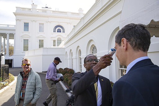 A member of the media, right, gets their temperature taken by member of the White House physicians office, over concerns about the coronavirus outside the James Brady Briefing Room at the White House, Saturday, March 14, 2020, in Washington.  The White House announced Saturday that it is now conducting temperature checks on anyone who is in close contact with President Donald Trump and Vice President Mike Pence. The vast majority of people recover from the new coronavirus. According to the World Health Organization, most people recover in about two to six weeks, depending on the severity of the illness.(AP Photo/Alex Brandon)