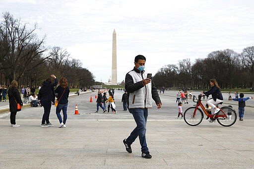 A man wears a face mask as he visits the National Mall in Washington, Saturday, March 14, 2020. For most people, the new coronavirus causes only mild or moderate symptoms, such as fever and cough. For some, especially older adults and people with existing health problems, it can cause more severe illness, including pneumonia. (AP Photo/Patrick Semansky)