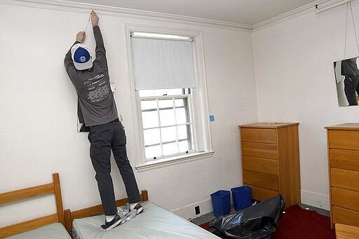 Wheaton sophomore Alex Berg helps clean out his girlfriend's dorm room on Saturday, March 14, 2020 in Norton, Mass.  Students at the Norton campus have until March 22 to vacate all student residence halls and houses to help prevent the spread of COVID-19 coronavirus. The vast majority of people recover from the new coronavirus.  Gov. Charlie Baker issued an emergency order Friday banning most gatherings of more than 250 people as the state works to limit the spread of the new coronavirus. According to the World Health Organization, most people recover in about two to six weeks, depending on the severity of the illness.  (Mark Stockwell/The Sun Chronicle via AP)