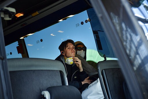 Passengers wear face masks to prevent spread of coronavirus inside of a bus at bus station in Vitoria, northern Spain, Saturday, March 14, 2020. Spain's prime minister has announced a two-week state of emergency from Saturday in a bid to contain the new coronavirus outbreak. For most people, the new COVID-19 coronavirus causes only mild or moderate symptoms, such as fever and cough, but for some, especially older adults and people with existing health problems, it can cause more severe illness, including pneumonia. (AP Photo/Alvaro Barrientos)