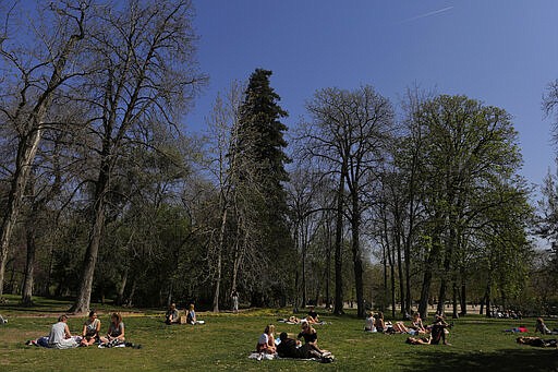 People enjoy the sun at the Retiro Park in Madrid, Spain, Saturday, March 14, 2020. Spanish Prime Minister Pedro Sanchez said his government will declare a two-week state of emergency starting Saturday, giving itself extraordinary powers including the mobilization of the armed forces, to confront the COVID-19 outbreak. For some, especially older adults and people with existing health problems, it can cause more severe illness, including pneumonia. (AP Photo/Manu Fernandez)