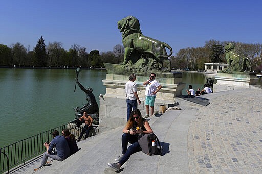 People enjoy the sun at the Retiro Park in Madrid, Spain, Saturday, March 14, 2020. Spanish Prime Minister Pedro Sanchez said his government will declare a two-week state of emergency starting Saturday, giving itself extraordinary powers including the mobilization of the armed forces, to confront the COVID-19 outbreak. For some, especially older adults and people with existing health problems, it can cause more severe illness, including pneumonia. (AP Photo/Manu Fernandez)