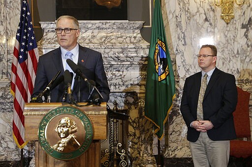 Gov. Jay Inslee, left, is joined by Superintendent of Public Instruction Chris Reykdal as he discusses the expansion of school closures and prohibition of large gatherings across all of Washington in an effort to slow the spread of the new coronavirus, Friday, March 13, 2020. Inslee says he issued the executive orders because the virus is spreading rapidly across the state. Previously, school closures and prohibitions of large gatherings had only been ordered in the three counties with the highest numbers of cases. (AP Photo/Rachel La Corte)