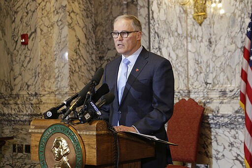 Washington Gov. Jay Inslee talks to the media about his decision to expand school closures and prohibition of large gatherings across all of Washington in an effort to slow the spread of the new coronavirus, Friday, March 13, 2020. Inslee issued the executive orders, saying the virus is spreading rapidly across the state. Previously, school closures and prohibitions of large gatherings had only been ordered in the three counties with the highest numbers of cases. For most people, the new coronavirus causes only mild or moderate symptoms. For some it can cause more severe illness.  (AP Photo/Rachel La Corte)