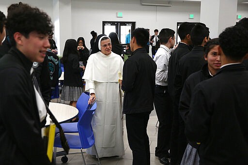 Sister Mary Jordan Hoover, the principal of the St. John Paul II Catholic School, talks with students during lunch break in Phoenix, Ariz., on Feb. 26, 2020. In the western suburbs of Phoenix, enrollment is surging at this new Catholic high school built to serve a fast-growing, heavily Hispanic community. (AP Photo/Dario Lopez-MIlls)