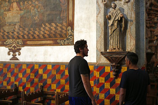 People visit the main church at the Mission San Xavier del Bac in Tucson, Ariz., Friday, Feb. 21, 2020. It was founded as a Catholic mission by Father Eusebio Kino in 1692 when Southern Arizona was part of New Spain. (AP Photo/Dario Lopez-MIlls)