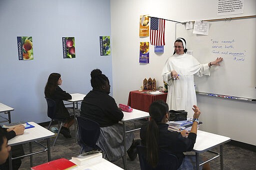 Sister Regina Ann Tonn teaches a religion class at the St. John Paul II Catholic School in Phoenix, Ariz., on Feb. 26, 2020. In the western suburbs of Phoenix, enrollment is surging at this new Catholic high school built to serve a fast-growing, heavily Hispanic community. (AP Photo/Dario Lopez-MIlls)