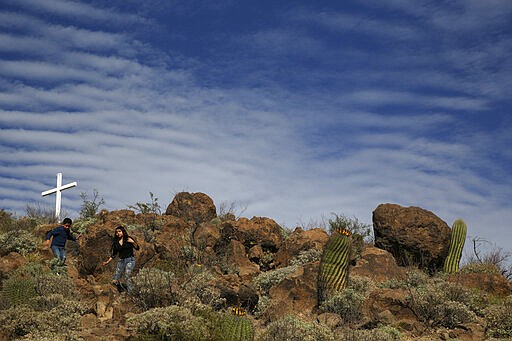 Children walk down Grotto Hill next to the Mission San Xavier del Bac in Tucson, Ariz., Friday, Feb. 21, 2020. San Xavier Mission was founded as a Catholic mission by Father Eusebio Kino in 1692 when Southern Arizona was part of New Spain. The hill is named informally for a small religious shrine tucked into a rocky grotto on its flanks. (AP Photo/Dario Lopez-MIlls)