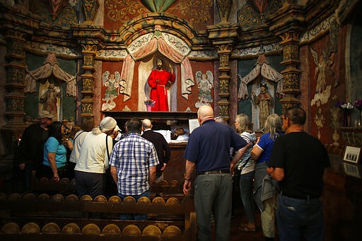 People visit the main church at the Mission San Xavier del Bac in Tucson, Ariz., Friday, Feb. 21, 2020. It was founded as a Catholic mission by Father Eusebio Kino in 1692 when Southern Arizona was part of New Spain. (AP Photo/Dario Lopez-MIlls)