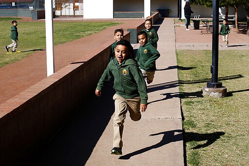 Children run during recess at the St. Agnes Elementary School in Phoenix, Ariz., on March 3, 2020. In 2016, the student body at St. Agnes was two-thirds Hispanic; the figure is now 95%, and virtually every student receives financial aid through state-approved tax credit programs that extend to private schools. (AP Photo/Dario Lopez-MIlls)