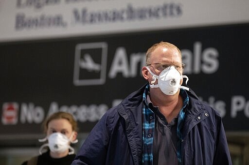 Passengers on a flight from Paris arrive at Logan International Airport in Boston, Friday, March, 13, 2020. Beginning at midnight Friday most Europeans will be banned from entering the United States for 30 days to try to slow down the spread of the coronavirus. Americans returning from Europe will be subject to enhanced health screening. For most people, the new coronavirus causes only mild or moderate symptoms, such as fever and cough. For some, especially older adults and people with existing health problems, it can cause more severe illness, including pneumonia. The vast majority of people recover from the new virus. (AP Photo/Michael Dwyer)