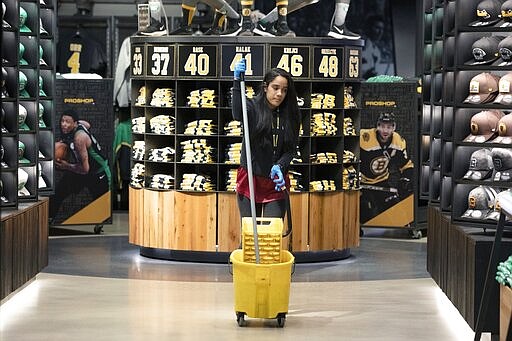 A cleaning person works in the pro shop selling merchandise for both the Boston Celtics and the Bruins at TD Garden in Boston, Saturday, March, 14, 2020. The NBA and the NHL, along with most major sports and sporting events in the United States have suspended play due to concern about the new coronavirus. For most people, the new coronavirus causes only mild or moderate symptoms, such as fever and cough. For some, especially older adults and people with existing health problems, it can cause more severe illness, including pneumonia. The vast majority of people recover from the new virus. (AP Photo/Michael Dwyer)