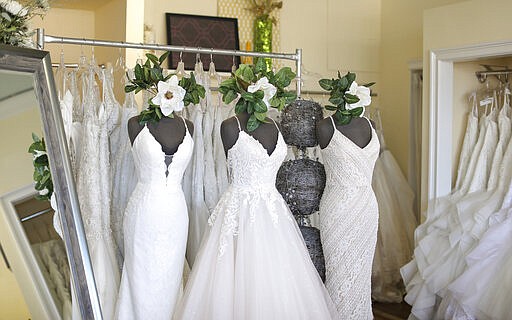 Wedding dresses are displayed at Complete Bridal, a shop in East Dundee, Illinois, on February 28, 2020. The store is heavily reliant on China for manufacturing. Factory closures there have meant fewer choices for brides.  Those with weddings coming up soon have to buy off the rack and forego customization. (AP Photo/Teresa Crawford)