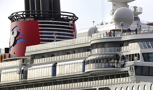 In this Monday, March 9, 2020 photo, the Disney Dream departs Port Canaveral, Fla. Disney Cruise Line announced that after Saturday, March 14, all of their cruises will suspend operations through the end of the month in response to the coronavirus threat. (Joe Burbank/Orlando Sentinel via AP)