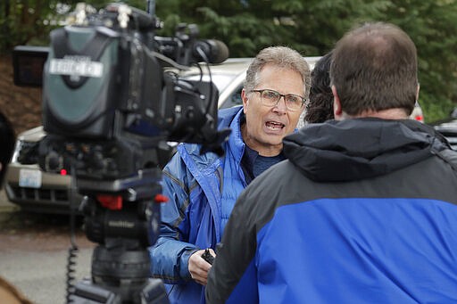 In this March 12, 2020, photo, Scott Sedlacek becomes animated as talks to reporters outside Life Care Center in Kirkland, Wash., near Seattle. The facility has been at the center of the coronavirus outbreak in the state, and Sedlacek &#151; who also has tested positive for the virus &#151; said he and his siblings have barely spoken to their father who lives inside the center, and in addition to testing positive for the coronavirus, has blindness, neuropathy, and has difficulty using a phone, saying he is more of an &quot;inmate&quot; than a patient. Residents of assisted living facilities and their loved ones are facing a grim situation as the coronavirus spreads across the country, placing elderly people especially at risk. (AP Photo/Ted S. Warren)