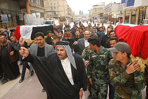 Mourners carry the flag-draped coffins of two fighters of the Popular Mobilization Forces who were killed during the US attack on against militants in Iraq, during their funeral procession at the Imam Ali shrine in Najaf, Iraq, Saturday, March 14, 2020. The U.S. launched airstrikes on Thursday in Iraq, targeting the Iranian-backed Shiite militia members believed responsible for a rocket attack that killed and wounded American and British troops at a base north of Baghdad. (AP Photo/Anmar Khalil)