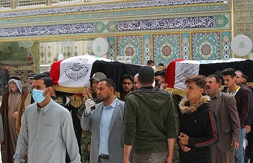 Mourners carry the flag-draped coffins of two fighters of the Popular Mobilization Forces who were killed during the US attack against militants in Iraq, during their funeral procession at the Imam Ali shrine in Najaf, Iraq, Saturday, March 14, 2020. The U.S. launched airstrikes on Thursday in Iraq, targeting the Iranian-backed Shiite militia members believed responsible for a rocket attack that killed and wounded American and British troops at a base north of Baghdad. (AP Photo/Anmar Khalil)