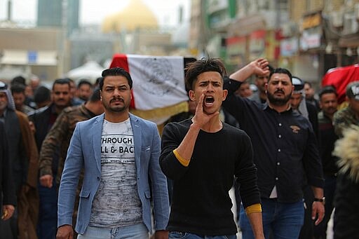 Mourners and militia fighters chant slogans against the U.S.during the funeral procession of two fighters of the Popular Mobilization Forces who were killed during the US attack against militants in Iraq, during their funeral procession at the Imam Ali shrine in Najaf, Iraq, Saturday, March 14, 2020. The U.S. launched airstrikes on Thursday in Iraq, targeting the Iranian-backed Shiite militia members believed responsible for a rocket attack that killed and wounded American and British troops at a base north of Baghdad. (AP Photo/Anmar Khalil)