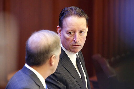 Senate president Bill Galvano, R-Bradenton, right, confers with Sen. Wilton Simpson, R-Trilby, during a session Friday March 13, 2020 in Tallahassee, Fla.  The spread of the new coronavirus has stoked worries about Florida's economy, prompting lawmakers to rethink spending on big-ticket items as negotiations continue over the state budget. (AP Photo/Steve Cannon)