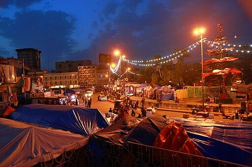 In this Friday, March 6, 2020 photo, protesters gather in Tahrir Square in Baghdad, Iraq. Where once the square had seen thousands every day, now only a few hundred protesters turn up. They are struggling to keep their movement going after one set-back after another, now capped by fears over the coronavirus outbreak. For most people, the virus causes only mild or moderate symptoms. For some it can cause more severe illness. (AP Photo/Hadi Mizban)