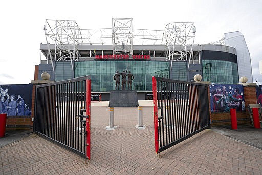 Almost empty stadium area around Manchester United's Old Trafford Stadium, in Manchester, England, Saturday March 14, 2020, after all English soccer games were cancelled due to the spread of the COVID-19 Coronavirus. For most people, the new COVID-19 coronavirus causes only mild or moderate symptoms, but for some it can cause more severe illness. (AP Photo/Jon Super)