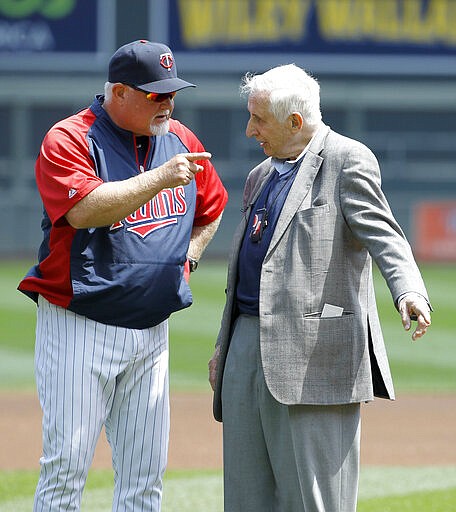 FILE - In this May 18, 2014, file photo, Star Tribune of Minneapolis sports columnist Sid Hartman, right, who turned 100 on Sunday, March 15, 2020, talks with Minnesota Twins manager Ron Gardenhire as Hartman was honored by the Twins organization before a baseball game against the Seattle Mariners in Minneapolis. (AP Photo/Ann Heisenfelt, File)