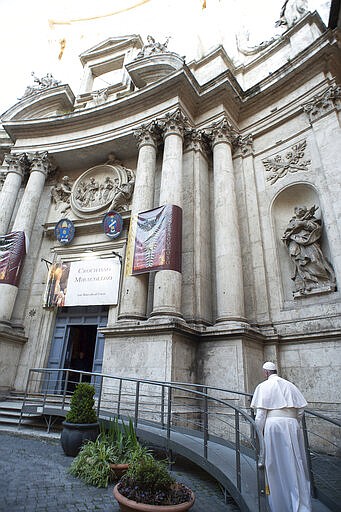 Pope Francis walks to reach S. Marcello al Corso church, where there is a miraculous crucifix that in 1552 was carried in a procession around Rome to stop the great plague, Sunday, March 15, 2020. For most people, the new coronavirus causes only mild or moderate symptoms. For some, it can cause more severe illness, especially in older adults and people with existing health problems. (Vatican News via AP)