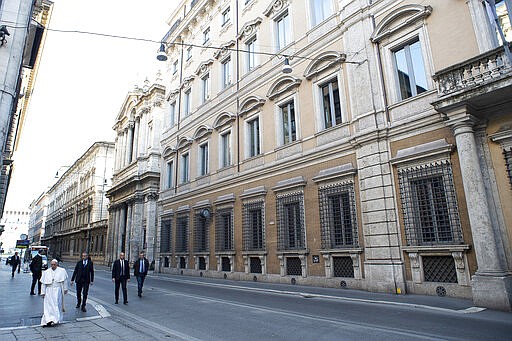 Pope Francis walks to reach S. Marcello al Corso church, where there is a miraculous crucifix that in 1552 was carried in a procession around Rome to stop the great plague, Sunday, March 15, 2020. For most people, the new coronavirus causes only mild or moderate symptoms. For some, it can cause more severe illness, especially in older adults and people with existing health problems. (Vatican News via AP)