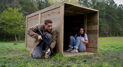 This image released by Universal Pictures shows Justin Hartley, left, and Sylvia Grace Crim in a scene from &quot;The Hunt.&quot; (Universal Pictures via AP)