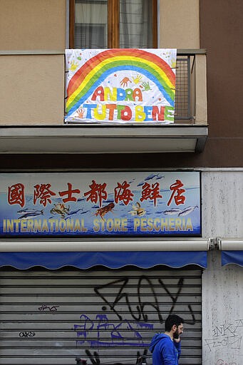 In this photo taken on Friday, March 13, 2020, a banner reading "Everything will be alright" hangs on a balcony in Milan, Italy. The nationwide lockdown to slow coronavirus is still early days for much of Italy, but Italians are already are showing signs of solidarity. This week, childrens drawings of rainbows are appearing all over social media as well as on balconies and windows in major cities ready, Andra tutto bene, Italian for Everything will be alright.  For most people, the new coronavirus causes only mild or moderate symptoms. For some, it can cause more severe illness, especially in older adults and people with existing health problems. (AP Photo/Luca Bruno)