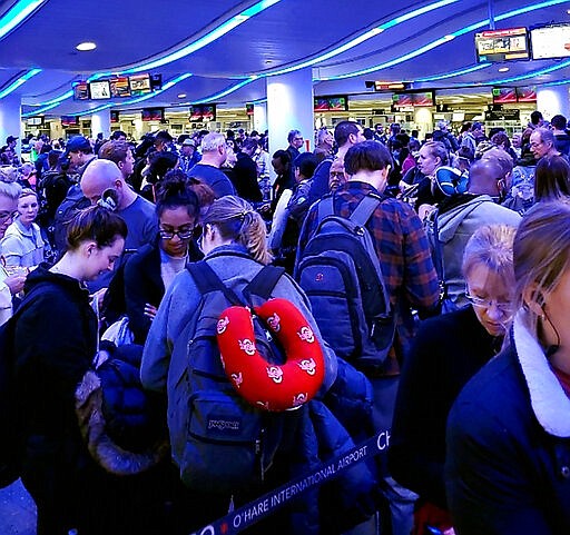 In this Saturday, March 14, 2020 photo provided by Elizabeth Pulvermacher travelers returning from Madrid wait in a coronavirus screening line at Chicago's O'Hare International Airport. Long lines and hourslong waits for required medical screenings greeted weary travelers returning to some U.S. airports amid coronavirus-related travel restrictions. (Elizabeth Pulvermacher via AP)