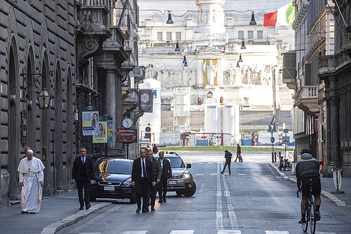 Pope Francis walks to reach S. Marcello al Corso church, where there is a miraculous crucifix that in 1552 was carried in a procession around Rome to stop the great plague, Sunday, March 15, 2020. For most people, the new coronavirus causes only mild or moderate symptoms. For some, it can cause more severe illness, especially in older adults and people with existing health problems. (Vatican News via AP)