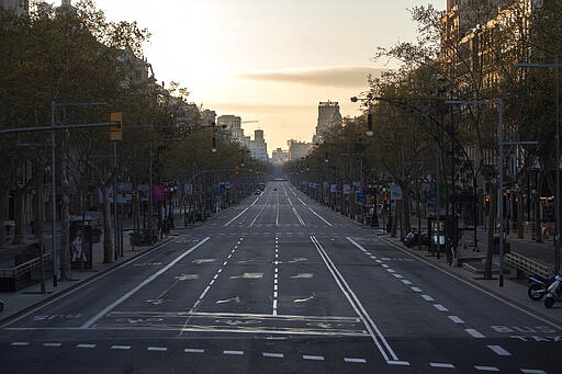 An avenue is seen empty in Barcelona, Spain, Sunday, March 15, 2020. Spain's government announced Saturday that it is placing tight restrictions on movements and closing restaurants and other establishments in the nation of 46 million people as part of a two-week state of emergency to fight the sharp rise in coronavirus infections. For most people, the new coronavirus causes only mild or moderate symptoms. For some, it can cause more severe illness, especially in older adults and people with existing health problems. (AP Photo/Joan Mateu)