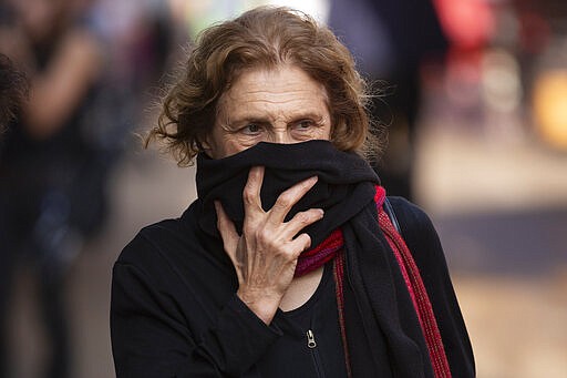 A woman covers her face as she shops at a food market in Tel Aviv, Israel, Sunday, March 15, 2020. ?Israel has imposed a number of tough restrictions to slow the spread of the new coronavirus. Prime Minister Benjamin Netanyahu announced that schools, universities, restaurants and places of entertainment will be closed to stop the spread of the coronavirus. He also encouraged people not to go to their workplaces unless absolutely necessary.  (AP Photo/Oded Balilty)