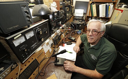 In this Friday, March 13, 2020 photo, Paul Buescher poses by his ham radio, in Northfield Center Township, Ohio. Buescher is one of 32 members of a group in northeastern Ohio that shares a farm packed with enough canned and dehydrated food and water to last for years. For those in the often-mocked &quot;prepper&quot; community, this is quickly becoming their &quot;I told you so&quot; moment, as panic buying has cleared store shelves across the U.S. amid growing fears that the new coronavirus will force many Americans to self-quarantine for weeks in their homes. (AP Photo/Tony Dejak)