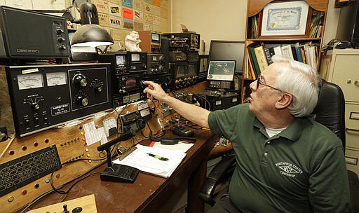 In this Friday, March 13, 2020 photo, Paul Buescher adjusts his ham radio, in Northfield Center Township, Ohio. Buescher is one of 32 members of a group in northeastern Ohio that shares a farm packed with enough canned and dehydrated food and water to last for years. For those in the often-mocked &quot;prepper&quot; community, this is quickly becoming their &quot;I told you so&quot; moment, as panic buying has cleared store shelves across the U.S. amid growing fears that the new coronavirus will force many Americans to self-quarantine for weeks in their homes. (AP Photo/Tony Dejak)