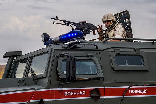 FILE - In this Oct. 25, 2019 file photo, Russian soldier mans a machine gun during a patrol near Syrian and Turkish border in north Syria. In a world gripped by a pandemic, global unrest and a fast-moving news cycle, it can be difficult to remember that the war in Syria is still happening. (AP Photo/Baderkhan Ahmad, File)