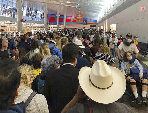In this photo provided by Austin Boschen, people wait in line to go through the customs at Dallas Fort Worth International Airport in Grapevine, Texas, Saturday, March 14, 2020. International travelers reported long lines at the customs at the airport Saturday as staff took extra precautions to guard against the new coronavirus, The Dallas Morning News reports. Boschen said it took him at least 4 hours to go through the customs. (Austin Boschen via AP)