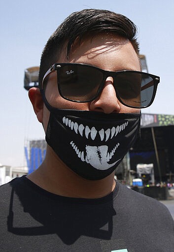 A music fan wears a stylize protective mask as a precaution against the spread of the new coronavirus, at the Vive Latino Music Festival, in Mexico City, Saturday, March 14, 2020. On Friday afternoon organizers confirmed that the 21st edition of the festival will go on as planned. However, preventive measures will be taken, such as checking the temperature of the attendees upon admission and providing antibacterial gel. (AP Photo/Christian Palma)